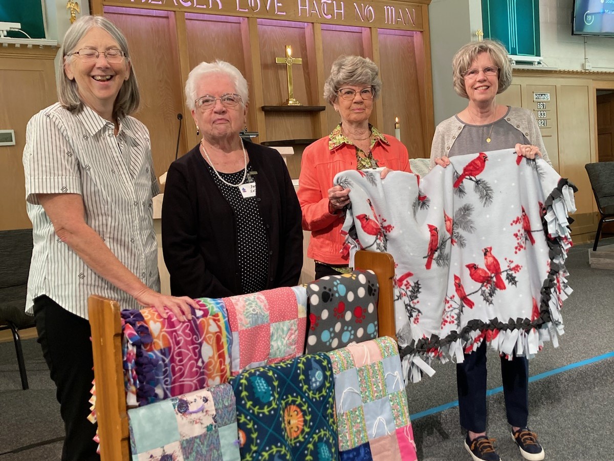 Women holding quilts